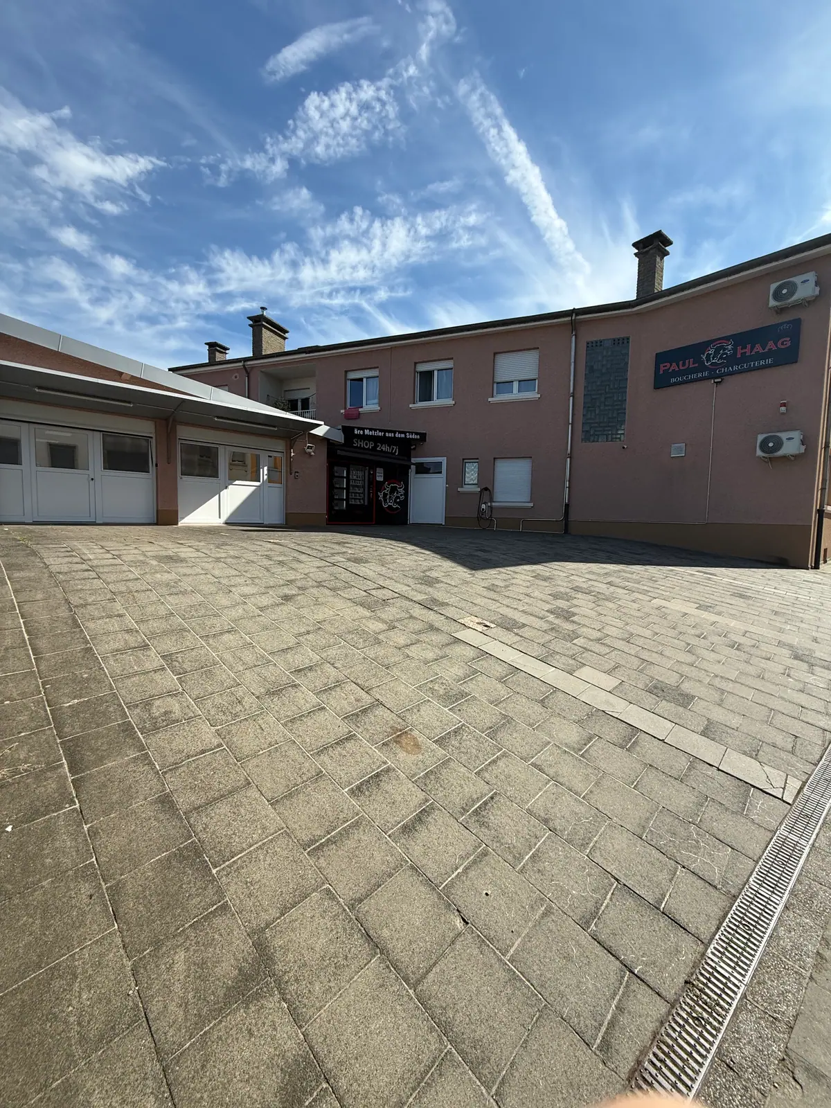 De Parking hannert dem Haus, mat de Garagen an dem Agank zum Shop 24h/7j